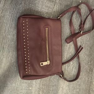 Deep red, burgundy, color Jennifer Lopez over the shoulder purse.